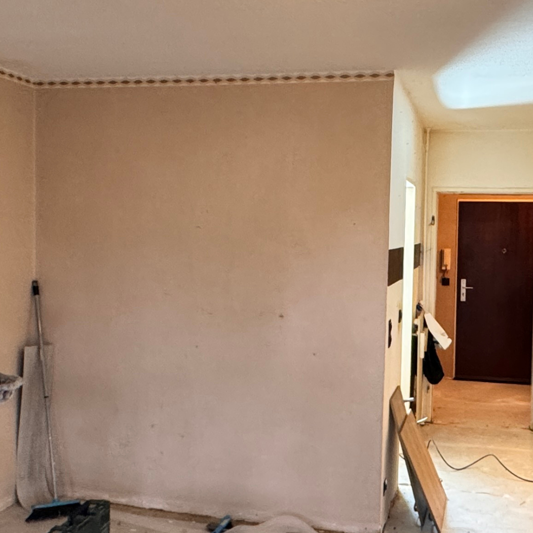 Abgetrennter, leerer Küchenraum mit alten Wänden vor dem Wanddurchbruch.